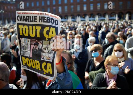Ein Mann schwingt eine Charlie Hebdo Zeitung mit der Aufschrift „All that for this“. Nach der Tötung von Samuel Paty, Lehrer für Geographie-Geschichte, in Conflans-Sainte-Honorine (Yvelines) am 16.. Oktober versammelten sich mehrere Tausende von Menschen auf dem Hauptplatz von Toulouse, vor dem Rathaus, dem Capitole, um die Meinungsfreiheit zu verteidigen und Samuel zu ehren. Einige Leute kamen mit einem Cover von Charlie Hebdo, da der Lehrer getötet wurde, nachdem er seinen Schülern die Karikaturen von Charlie Hebdo von Muhammed gezeigt hatte. Der Mörder wurde anschließend von der französischen Polizei getötet. Am 18.. Oktober 2020 in Toulous Stockfoto