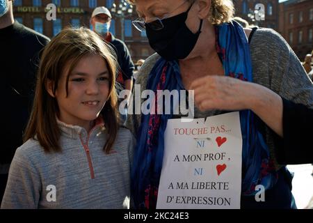 Eine Großmottin mit ihrer Enkelin hält ein Plakat mit der Aufschrift „Berühre weder meinen Lehrer noch meine Meinungsfreiheit“. Nach der Tötung von Samuel Paty, Lehrer für Geographie-Geschichte, in Conflans-Sainte-Honorine (Yvelines) am 16.. Oktober versammelten sich mehrere Tausende von Menschen auf dem Hauptplatz von Toulouse, vor dem Rathaus, dem Capitole, um die Meinungsfreiheit zu verteidigen und Samuel zu ehren. Einige Leute kamen mit einem Cover von Charlie Hebdo, da der Lehrer getötet wurde, nachdem er seinen Schülern die Karikaturen von Charlie Hebdo von Muhammed gezeigt hatte. Der Mörder wurde durch das französische Pol getötet Stockfoto