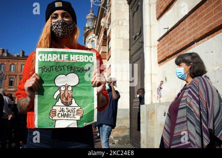 Eine Frau hält ein Cover der Zeitung Charlie Hebdo mit der Aufschrift „alles ist vergeben“ mit einer Karikatur des Propheten Muhammed. Nach der Tötung von Samuel Paty, Lehrer für Geographie-Geschichte, in Conflans-Sainte-Honorine (Yvelines) am 16.. Oktober versammelten sich mehrere Tausende von Menschen auf dem Hauptplatz von Toulouse, vor dem Rathaus, dem Capitole, um die Meinungsfreiheit zu verteidigen und Samuel zu ehren. Einige Leute kamen mit einem Cover von Charlie Hebdo, da der Lehrer getötet wurde, nachdem er seinen Schülern die Karikaturen von Charlie Hebdo von Muhammed gezeigt hatte. Der Mörder wurde von der französischen Polikerin getötet Stockfoto