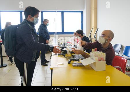 Ein Mann aus dem medizinischen Personal übergibt das Reagenzglas einem Bürger, bevor er den Tupfer am 19.. Oktober 2020 in Padua, Italien, einnahm. Die Stadt Padua, die ich in verschiedenen Schwerpunkten der als Tupfer für die Staatsbürgerschaft verwendeten Gebiete etabliert habe. Hier die Pufferfläche unterhalb des Euganeo-Stadions. Familien, Kinder und ältere Menschen gehen von heute Morgen an unter ärztlicher Verschreibung zur Durchführung des Tupfers. (Foto von Roberto Silvino/NurPhoto) Stockfoto