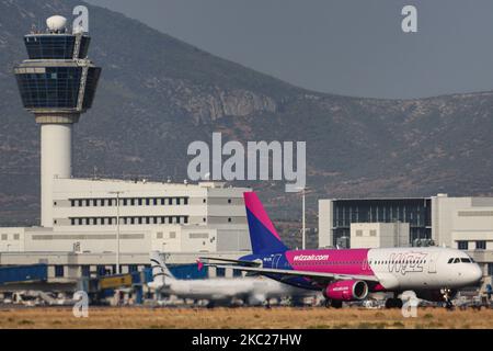 Ein Flugzeug der Wizz Air Budget Airline Airbus A320-200, das vor dem Terminal und dem Kontrollturm des Flughafens Athen beim Rollen, Start, Drehen und Fliegen von der griechischen Hauptstadt, dem Internationalen Flughafen Athen ATH LGAV, gesehen wird. Das Schmalkarosserie-Flugzeug Airbus A320 hat die Zulassung HA-LPL und wird von 2x IAE-Düsenmotoren angetrieben. Wizzair ist eine europäische Ultra Low Cost Carrier-Fluggesellschaft mit Sitz in Budapest, Ungarn, und verfügt über eine Flotte von 135 Flugzeugen, die 150 Ziele anfliegt. Im Sommer 2020 sank der Passagierverkehr weltweit aufgrund der Coronavirus Covid-19-Pandemie, die eine betrifft Stockfoto