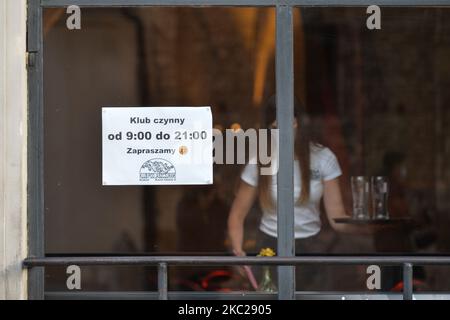 Ein Schild mit den Öffnungszeiten auf dem Fenster von 'Klub Pod Jaszczurami' in Krakau. Heute meldete das Gesundheitsministerium 9.291 neue Fälle von COVID-19 in Polen, darunter eine Rekordzahl von 1.486 in der Woiwodschaft Malopolskie. Außerdem lebt jede dritte Person, die in der Woiwodschaft Malopolskie mit COVID-19 diagnostiziert wurde, in Krakau. Am Dienstag, den 20. Oktober 2020, in Krakau, Polen. (Foto von Artur Widak/NurPhoto) Stockfoto