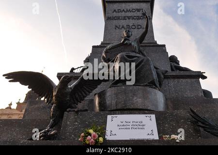 Ein Schild mit der Aufschrift „in der Nacht der Poesie dankt Krakau seinen Dichtern“, das am Fuße der Adam-Mickiewicz-Statue auf dem Marktplatz von Krakau zu sehen ist. Heute meldete das Gesundheitsministerium 9.291 neue Fälle von COVID-19 in Polen, darunter eine Rekordzahl von 1.486 in der Woiwodschaft Malopolskie. Außerdem lebt jede dritte Person, die in der Woiwodschaft Malopolskie mit COVID-19 diagnostiziert wurde, in Krakau. Am Dienstag, den 20. Oktober 2020, in Krakau, Polen. (Foto von Artur Widak/NurPhoto) Stockfoto