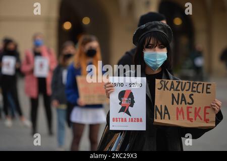 Die pro-Choice-Aktivistin hält ein Plakat mit dem Aufdruck „Women Strike“ und ein Schild mit der Aufschrift „You verurteile US to Suffering“ im Zentrum von Krakau, einem Teil der Roten Zone des Coronavirus, während eines Protestes gegen ein Gesetz, das Abtreibung für irreversible Schäden am Feten verbietet. Morgen, am Donnerstag, dem 22. Oktober, wird das Verfassungsgericht den Antrag einer Gruppe von Abgeordneten der Partei für Recht und Gerechtigkeit (PiS) zur Verfassungsmäßigkeit der sogenannten eugenischen Abtreibung prüfen, die im Falle des Verdachts auf die Krankheit eines Kindes oder dessen Beeinträchtigung durchgeführt wird. Eine Gruppe von PiS-Abgeordneten reichte einen Antrag an t Stockfoto