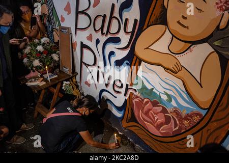Freunde und mehrere Unterstützer der philippinischen Aktivistin Reina Mae versammeln sich am Mittwochabend an der Katipunan Ave. In Quezon City zu einem Wandgemälde, das in Erinnerung an Baby River Nasino gewidmet ist. Die Teilnehmer zünden Kerzen an, bieten Blumen an und stehen solidarisch mit Reina Mae Nasino in ihrer Trauer und fordern die Freilassung anderer politischer Gefangener. Quezon City, Manila, Philippinen, 21. Oktober 2020. (Foto von Mohd Sarajean/NurPhoto) Stockfoto