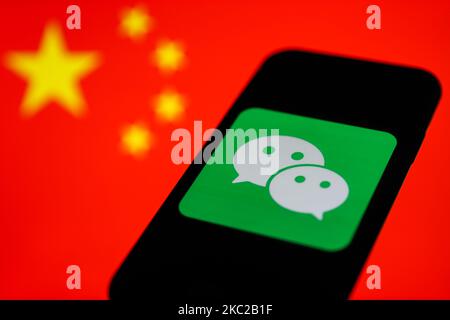 Das WeChat-Logo, das auf einem Telefonbildschirm angezeigt wird, ist mit einer chinesischen Flagge im Hintergrund auf diesem Illustrationsfoto zu sehen, das am 21. Oktober 2020 in Krakau, Polen, aufgenommen wurde. (Fotoillustration von Jakub Porzycki/NurPhoto) Stockfoto