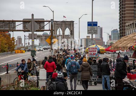 Menschen unter ihnen viele Touristen und Verkehr mit Autos von der Brooklyn Bridge in New York City in den Vereinigten Staaten, wie sie an einem bewölkten Tag mit Touristen und Einheimischen auf ihr gesehen werden. Die berühmte Brücke, ein Wahrzeichen für NYC und die Vereinigten Staaten von Amerika, ist eine hybride Hängebrücke mit Kabelgestellen, die den East River zwischen den Stadtteilen Manhattan und Brooklyn überspannt. Die historische NY Wahrzeichen Brücke wurde zwischen 1869 und 1883 gebaut. New York, USA am 13. Februar 2020 (Foto von Nicolas Economou/NurPhoto) Stockfoto