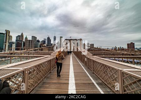 Blick von der Brooklyn Bridge auf Downtown Manhattan. Die Brooklyn Bridge in New York City in den Vereinigten Staaten, wie sie an einem bewölkten Tag mit Touristen und Einheimischen auf ihr zu sehen ist. Die berühmte Brücke, ein Wahrzeichen für NYC und die Vereinigten Staaten von Amerika, ist eine hybride Hängebrücke mit Kabelgestellen, die den East River zwischen den Stadtteilen Manhattan und Brooklyn überspannt. Die historische NY Wahrzeichen Brücke wurde zwischen 1869 und 1883 gebaut. New York, USA am 13. Februar 2020 (Foto von Nicolas Economou/NurPhoto) Stockfoto