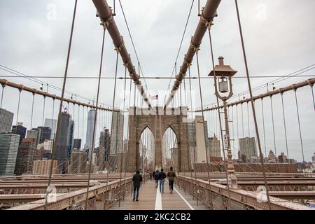 Blick von der Brooklyn Bridge auf Downtown Manhattan. Die Brooklyn Bridge in New York City in den Vereinigten Staaten, wie sie an einem bewölkten Tag mit Touristen und Einheimischen auf ihr zu sehen ist. Die berühmte Brücke, ein Wahrzeichen für NYC und die Vereinigten Staaten von Amerika, ist eine hybride Hängebrücke mit Kabelgestellen, die den East River zwischen den Stadtteilen Manhattan und Brooklyn überspannt. Die historische NY Wahrzeichen Brücke wurde zwischen 1869 und 1883 gebaut. New York, USA am 13. Februar 2020 (Foto von Nicolas Economou/NurPhoto) Stockfoto