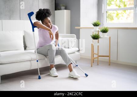 Gebrochenes Bein Bei Der Wiederherstellung Der Besetzung. Frau Mit Verletzung Auf Dem Sofa Stockfoto