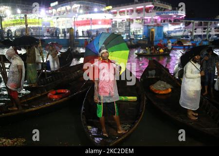 Bootsführer warten am 23. Oktober 2020 an einem regnerischen Tag am Buriganga River in Dhaka, Bangladesch, auf Passagiere. Niederschläge treten in verschiedenen Teilen von Bangladesch aufgrund von Depressionen über der Bucht von Bengalen auf. (Foto von Rehman Asad/NurPhoto) Stockfoto