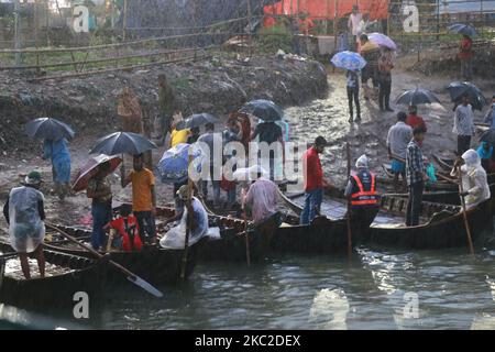 Bootsführer warten am 23. Oktober 2020 an einem regnerischen Tag am Buriganga River in Dhaka, Bangladesch, auf Passagiere. Niederschläge treten in verschiedenen Teilen von Bangladesch aufgrund von Depressionen über der Bucht von Bengalen auf. (Foto von Rehman Asad/NurPhoto) Stockfoto