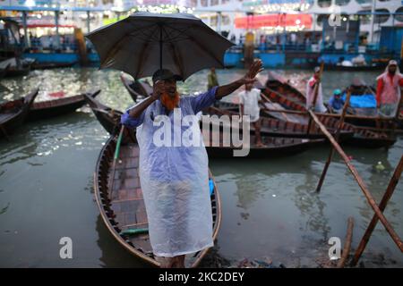 Bootsführer warten am 23. Oktober 2020 an einem regnerischen Tag am Buriganga River in Dhaka, Bangladesch, auf Passagiere. Niederschläge treten in verschiedenen Teilen von Bangladesch aufgrund von Depressionen über der Bucht von Bengalen auf. (Foto von Rehman Asad/NurPhoto) Stockfoto