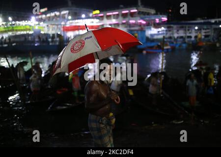 Bootsführer warten am 23. Oktober 2020 an einem regnerischen Tag am Buriganga River in Dhaka, Bangladesch, auf Passagiere. Niederschläge treten in verschiedenen Teilen von Bangladesch aufgrund von Depressionen über der Bucht von Bengalen auf. (Foto von Rehman Asad/NurPhoto) Stockfoto