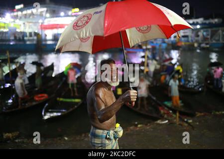 Bootsführer warten am 23. Oktober 2020 an einem regnerischen Tag am Buriganga River in Dhaka, Bangladesch, auf Passagiere. Niederschläge treten in verschiedenen Teilen von Bangladesch aufgrund von Depressionen über der Bucht von Bengalen auf. (Foto von Rehman Asad/NurPhoto) Stockfoto