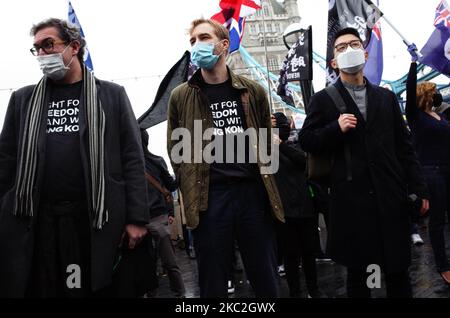 Der Gründer der Nichtregierungsorganisation Hong Kong Watch Benedict Rogers (L), Direktor der Anti-Sklaverei-Stiftung Arise Luke de Pulford (C) und der Exil-Prodemokratie-Aktivist Nathan Law (R) aus Hongkong nehmen an einer Kundgebung „Save 12 HK youngers“ im Potters Fields Park neben der Tower Bridge in London, England, Teil. Am 24. Oktober 2020. Die Kampagne „Save 12 HK Youngers“ fordert die Freilassung von 12 jungen pro-demokratischen Aktivisten, die seit August auf dem chinesischen Festland abgehalten wurden, nachdem sie beim Versuch erwischt wurden, mit dem Boot aus Hongkong zu fliehen, angeblich nach Taiwan. Die heutige Kundgebung in London markiert den ersten öffentlichen Auftritt von Law seit seiner Gründung Stockfoto