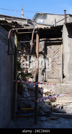 Eine vertikale Aufnahme eines verwitterten alten Hauses in einem Zustand des Verderbens mit einer rostigen Leiter davor Stockfoto