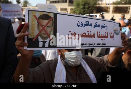 Palästinensische Demonstranten heben Plakate auf, die ein durchgestrichenes Bild des französischen Präsidenten Emmanuel Macron während eines Protestes gegen die Veröffentlichung einer Karikatur des Propheten Mohammad in Frankreich und Macrons Kommentare vor dem französischen Kulturzentrum in Gaza-Stadt am 26. Oktober 2020 zeigen. (Foto von Majdi Fathi/NurPhoto) Stockfoto