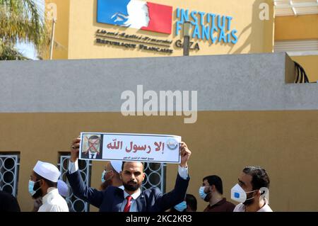 Palästinensische Demonstranten heben Plakate auf, die ein durchgestrichenes Bild des französischen Präsidenten Emmanuel Macron während eines Protestes gegen die Veröffentlichung einer Karikatur des Propheten Mohammad in Frankreich und Macrons Kommentare vor dem französischen Kulturzentrum in Gaza-Stadt am 26. Oktober 2020 zeigen. (Foto von Majdi Fathi/NurPhoto) Stockfoto