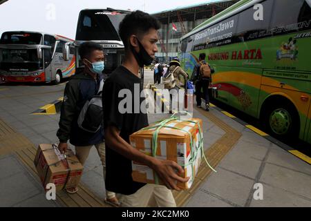 Am 26. Oktober 2020 begannen die Reisenden, den Busbahnhof Pulo Gebang, Cakung, Jakarta, zu beleben. Die Reisenden nutzten die langen Ferien und fuhren gemeinsam nach Hause, wenn die Regierung die Vorschriften während der Pandemie lockerte, indem sie das Gesundheitsprotokoll durch das Tragen einer Maske, das Tragen eines Händedesinfektionsmittels und das Halten der Distanz (die Last) der Passagiere zu 50 Prozent in jedem einzelnen Bus einsetzte. Dasril Roszandi (Foto von Dasril Roszandi/NurPhoto) Stockfoto