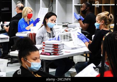 Mitarbeiter des Wahlbüros tragen Gesichtsmasken und Handschuhe, während sie am 26. Oktober 2020 im Wahlduplikationsraum des Wahlbüros von Orange County in Orlando, Florida, Briefwahlabstimmungen verarbeiten. Neun Tage vor den Wahlen vom 3. November haben bereits mehr Menschen in den diesjährigen Präsidentschaftswahlen ihre Stimme abgegeben, als im Rennen 2016 vorzeitig oder abwesend gewählt haben. (Foto von Paul Hennessy/NurPhoto) Stockfoto