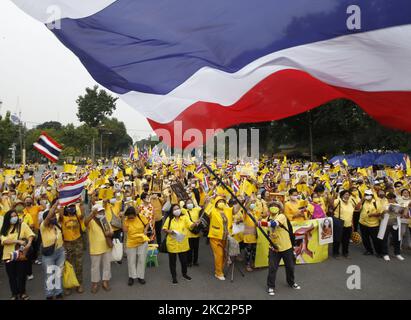 Pro-Royalisten in gelben Hemden, während sie am 27. Oktober 2020 Porträts der thailändischen Königsfamilie während einer Unterstützungsmonarchie im Lumpini-Park in Bangkok hielten. (Foto von Chaiwat Subprasom/NurPhoto) Stockfoto