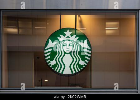 Nahaufnahme einer beleuchteten grünen Starbuck Meerjungfrau oder Sirene aus der griechischen Mythologie mit dem Logo-Symbol an der Vorderseite eines Starbucks Coffee Shops in Midtown Manhattan, wo Menschen vorbei gehen. Starbucks Corporation ist die größte Kaffeehauskette der Welt, eine multinationale amerikanische Cafékette mit Hauptsitz in Seattle, Washington. NYC, Vereinigte Staaten von Amerika am 2020. Februar (Foto von Nicolas Economou/NurPhoto) Stockfoto