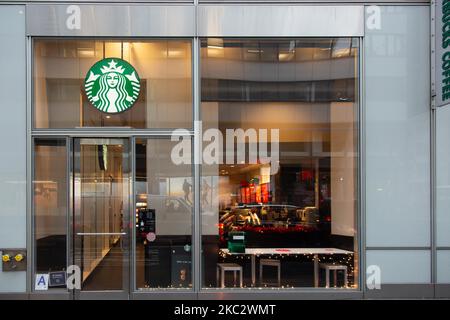 Ein Geschäft vor einem Starbucks Coffee Shop in Midtown Manhattan, in dem Leute vorbei laufen. Starbucks Corporation ist die größte Kaffeehauskette der Welt, eine multinationale amerikanische Cafékette mit Hauptsitz in Seattle, Washington. NYC, Vereinigte Staaten von Amerika am 2020. Februar (Foto von Nicolas Economou/NurPhoto) Stockfoto