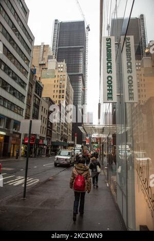 Ein Geschäft vor einem Starbucks Coffee Shop in Midtown Manhattan mit Menschen, die vorbei gehen und den Verkehr und Skyscrapper sichtbar. Starbucks Corporation ist die größte Kaffeehauskette der Welt, eine multinationale amerikanische Cafékette mit Hauptsitz in Seattle, Washington. NYC, Vereinigte Staaten von Amerika am 2020. Februar (Foto von Nicolas Economou/NurPhoto) Stockfoto