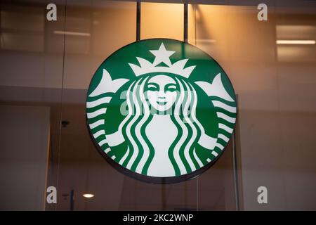 Nahaufnahme einer beleuchteten grünen Starbuck Meerjungfrau oder Sirene aus der griechischen Mythologie mit dem Logo-Symbol an der Vorderseite eines Starbucks Coffee Shops in Midtown Manhattan, wo Menschen vorbei gehen. Starbucks Corporation ist die größte Kaffeehauskette der Welt, eine multinationale amerikanische Cafékette mit Hauptsitz in Seattle, Washington. NYC, Vereinigte Staaten von Amerika am 2020. Februar (Foto von Nicolas Economou/NurPhoto) Stockfoto