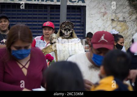 Anhänger von Santa Muerte kommen am 31. Oktober 2020 zu Besuch, um sie vor dem Abend in der rauen Nachbarschaft von Epito in Mexiko-Stadt, Mexiko, zu besuchen. Dies besteht aus einem Gebet und Dankbarkeit vor dem größten Fest dieses Bildes, das am 1. November gefeiert wird.und es ist, dass dieser Altar vor 19 Jahren aufgestellt wurde, der am meisten besuchte im Zentrum von Mexiko-Stadt. (Foto von Martin Gorostiola/NurPhoto) Stockfoto