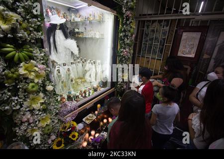 Anhänger von Santa Muerte kommen am 31. Oktober 2020 zu Besuch, um sie vor dem Abend in der rauen Nachbarschaft von Epito in Mexiko-Stadt, Mexiko, zu besuchen. Dies besteht aus einem Gebet und Dankbarkeit vor dem größten Fest dieses Bildes, das am 1. November gefeiert wird.und es ist, dass dieser Altar vor 19 Jahren aufgestellt wurde, der am meisten besuchte im Zentrum von Mexiko-Stadt. (Foto von Martin Gorostiola/NurPhoto) Stockfoto