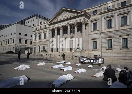 Während des Allerheiligen-Tages vor dem spanischen Parlament in Madrid, Spanien, am 1.. November 2002, während der zweiten Welle der Coronavirus-Pandemie (COVID19), protestieren Aktivisten der X-Rebellion AS vor dem spanischen Parlament gegen den Klimawandel. Die Demonstranten legten sich unter einem weißen Blatt auf den Boden, um an die Toten der Klimakrise zu erinnern. (Foto von Oscar Gonzalez/NurPhoto) Stockfoto