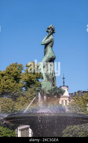 Helsinki, Finnland - 19. Juli 2022: Havis Amanda-Statue im Brunnen und am Marktplatz in Kaartinkaupunki unter blauem Himmel. Grüner Gürtel hinten. Stockfoto