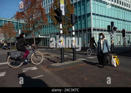 Das tägliche Leben in Eindhoven in den Niederlanden mit Menschen, die Gesichtsmasken tragen, während sie draußen spazieren oder auf dem Fahrrad unterwegs sind, wobei die Gesichtsmaske als Schutzmaßnahme gegen die Ausbreitung der Coronavirus-Pandemie Covid-19 verwendet wird. Niederlande seit Dienstag, dem 13. Oktober 2020, als der niederländische Premierminister Mark Rutte bekannt gab, dass das Land in eine teilweise Sperrung übergeht, Bars und Restaurants schließt, die obligatorische Verwendung von Gesichtsmasken in Innenräumen, die Beschränkung der Anzahl der Personen, die sich in Innenräumen versammeln, sowie sportliche Aktivitäten und mehr betroffen sind. Das Land war einer der größten Hotspots in Europa. Eind Stockfoto