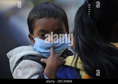 Am 09. November 2020 trifft ein Kind mit Gesichtsmaske zusammen mit seiner Mutter auf den Markt, um am Tihar-Festival in Kathmandu, Nepal, einkaufen zu gehen. (Foto von Narayan Maharjan/NurPhoto) Stockfoto