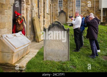 Ein Goth-Modell fotografiert die Fotografen vor der Whitby-Kirche während des jährlichen Goth-Wochenendes Stockfoto