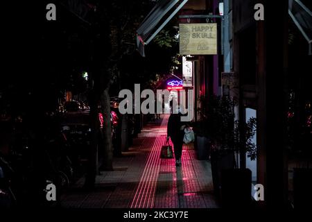 Eine Frau sah am 12. November 2020 während der zweiten COVID-19-Sperre in Griechenland auf einer leeren Straße in Athen, Griechenland, spazieren gehen. (Foto von Nikolas Kokovlis/NurPhoto) Stockfoto