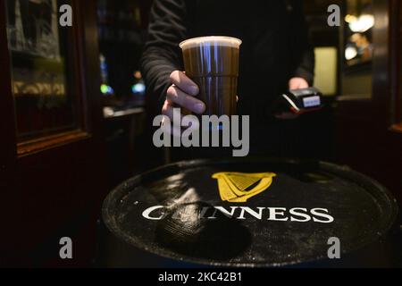 Ein Pint Guinness in einem Plastikbecher wird im Ha'Penny Bridge Pub im Zentrum von Dublin serviert. Am Samstag, den 14. November 2020, in Dublin, Irland. (Foto von Artur Widak/NurPhoto) Stockfoto