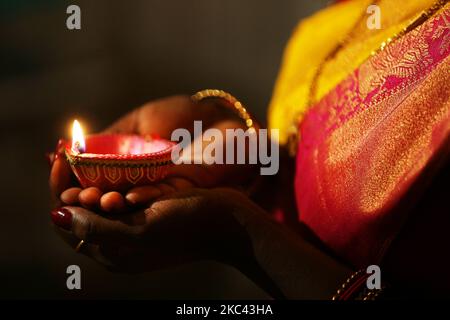 Hindu-Anhänger halten eine Diya (kleine Tonlampe) während des Festivals von Diwali in einem Hindu-Tempel in Toronto, Ontario, Kanada, am 14. November 2020. (Foto von Creative Touch Imaging Ltd./NurPhoto) Stockfoto