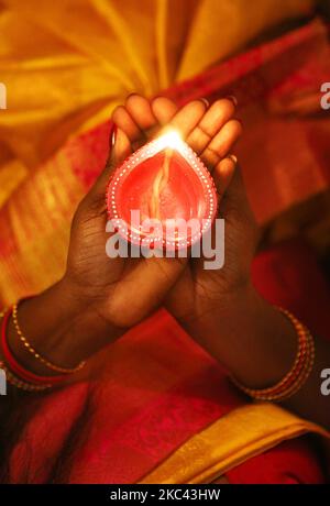 Hindu-Anhänger halten eine Diya (kleine Tonlampe) während des Festivals von Diwali in einem Hindu-Tempel in Toronto, Ontario, Kanada, am 14. November 2020. (Foto von Creative Touch Imaging Ltd./NurPhoto) Stockfoto