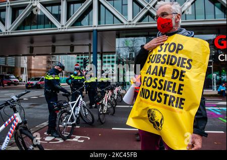 November 17., Den Haag. Mehrere Extinction Rebellion-Aktivisten und mit Hilfe der Dramatikerin Maria Goos und der niederländischen Schauspieler Sieger Sloot und Michiel de Jongdemand führten eine disruptive Aktion außerhalb des Gebäudes des Wirtschaftsministeriums und der Klimapolitik durch. Die Aktivisten fordern, dass die Subventionen für fossile Brennstoffe sofort gestoppt werden und die Gruppe fordert zudem die sofortige Freigabe der sogenannten Shell Papers. Während der Aktion versuchten die Aktivisten, das Gebäude zu erreichen, aber sie konnten das Gebäude wegen der hohen Polizeipräsenz nicht erreichen. Die Aktivisten beenden die Blockierung des Verkehrs, in Stockfoto