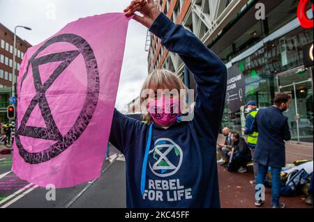 November 17., Den Haag. Mehrere Extinction Rebellion-Aktivisten und mit Hilfe der Dramatikerin Maria Goos und der niederländischen Schauspieler Sieger Sloot und Michiel de Jongdemand führten eine disruptive Aktion außerhalb des Gebäudes des Wirtschaftsministeriums und der Klimapolitik durch. Die Aktivisten fordern, dass die Subventionen für fossile Brennstoffe sofort gestoppt werden und die Gruppe fordert zudem die sofortige Freigabe der sogenannten Shell Papers. Während der Aktion versuchten die Aktivisten, das Gebäude zu erreichen, aber sie konnten das Gebäude wegen der hohen Polizeipräsenz nicht erreichen. Die Aktivisten beenden die Blockierung des Verkehrs, in Stockfoto