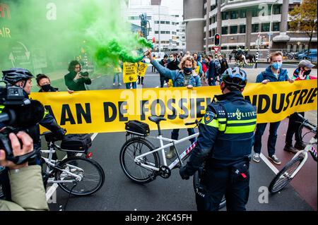 November 17., Den Haag. Mehrere Extinction Rebellion-Aktivisten und mit Hilfe der Dramatikerin Maria Goos und der niederländischen Schauspieler Sieger Sloot und Michiel de Jongdemand führten eine disruptive Aktion außerhalb des Gebäudes des Wirtschaftsministeriums und der Klimapolitik durch. Die Aktivisten fordern, dass die Subventionen für fossile Brennstoffe sofort gestoppt werden und die Gruppe fordert zudem die sofortige Freigabe der sogenannten Shell Papers. Während der Aktion versuchten die Aktivisten, das Gebäude zu erreichen, aber sie konnten das Gebäude wegen der hohen Polizeipräsenz nicht erreichen. Die Aktivisten beenden die Blockierung des Verkehrs, in Stockfoto