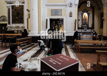 Der Tupfer in der Kirche San Severo fuori le mura im Bezirk Sanita in der Metropolstadt Neapel, Italien, wurde am 17. November 2020 für die Initiative „Tupfer der Solidarität“ eröffnet. Der Solidaritätsabstrich wurde für einen Preis von 18 Euro geschaffen, um sicherzustellen, dass auch die schwächeren Gruppen in einem der von der Wirtschaftskrise im Zusammenhang mit der Pandemie am stärksten betroffenen Bezirke einer Anti-Covid-Untersuchung unterzogen werden können. Eine Initiative, die vom Verein Fondazione Comunita di San Gennaro Onlus und SaDiSa, zusammen mit der Apotheke Mele und der Dritten Gemeinde von Neapel gefördert wird. Mit Solidarity Swab gibt es einen Paralle Stockfoto