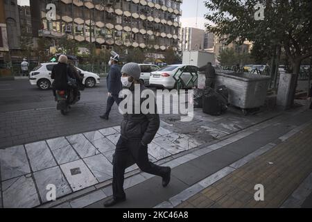 Ein iranischer Mann mit einer schützenden Gesichtsmaske geht am 17. November 2020 an einer Straße im Zentrum von Teheran entlang, während der Ausbruch der neuen Coronavirus-Krankheit (COVID-19) im Iran ausbrach. Da die dritte Welle des COVID-19-Ausbruchs iranische Menschen tötet, erwägt die Regierung eine zweiwöchige totale Sperre in der Hauptstadt ab November 21.. (Foto von Morteza Nikoubazl/NurPhoto) Stockfoto