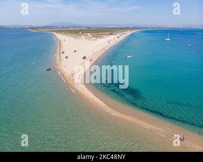 Luftaufnahme der exotischen Potamos - Epanomi Beach Sandbank in der Nähe der Stadt Thessaloniki von einer Drohne während der Pandemie des Coronavirus Covid-19 mit sozialen Distanzierungsmaßnahmen. Ein paar Sonnenschirme und Menschen werden gesehen, wie sie sich am Strand mit dem kristallklaren Wasser der Ägäis und des Mittelmeers entspannen. Der Epanomi Strand liegt in der Nähe der Stadt und des Flughafens, der für den tropischen Sandstrand, die Dünen, das Schiffswrack, die Sandbank und die Strandbars bekannt ist. Die Zahl der Touristen und Besucher in Griechenland und weltweit sank während der Pandemie-Ära, was die Tourismusbranche traf. E Stockfoto