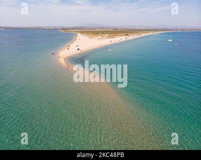 Luftaufnahme der exotischen Potamos - Epanomi Beach Sandbank in der Nähe der Stadt Thessaloniki von einer Drohne während der Pandemie des Coronavirus Covid-19 mit sozialen Distanzierungsmaßnahmen. Ein paar Sonnenschirme und Menschen werden gesehen, wie sie sich am Strand mit dem kristallklaren Wasser der Ägäis und des Mittelmeers entspannen. Der Epanomi Strand liegt in der Nähe der Stadt und des Flughafens, der für den tropischen Sandstrand, die Dünen, das Schiffswrack, die Sandbank und die Strandbars bekannt ist. Die Zahl der Touristen und Besucher in Griechenland und weltweit sank während der Pandemie-Ära, was die Tourismusbranche traf. E Stockfoto