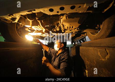 Ein Sri-lankischer Arbeiter, Raja, trägt einen Gesichtsschutz und eine Gesichtsmaske und ersetzt einen Reifen in einem Reifenladen, Nandula Radpflege, in Colombo, Sri Lanka. 20. November 2020. Sri Lanka übertraf laut Gesundheitsministerium 19000 bestätigte Covid-19-Patienten mit insgesamt 73 Covid-19-bezogenen Todesfällen und 12903 Genesungen bis Freitag (20). Generalleutnant Shavendra Silva, Chef der Armee Sri Lankas und Leiter des Nationalen Operationszentrums zur Prävention des COVID-19-Ausbruchs (NOCPCO), erklärte, dass die Task Force des Präsidenten auf COVID-19 zusammen mit den srilankischen Gesundheitsbehörden die Lage auf der isola einschätzen Stockfoto