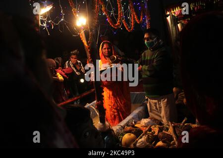 Eine hinduistische Frau, die Rituale durchführt und den sonnengott an einem künstlichen Teich anbetet, der auf der Straße oder auf dem Dach während des Chhath Puja Festivals in Neu Delhi am 20. November 2020 geschaffen wurde. Die Regierung von Delhi hat Gemeindefeiern von Chhath Puja an Flussufern, Ghats und Tempeln unter einer zunehmenden Anzahl von COVID-19-Fällen verboten. (Foto von Mayank Makhija/NurPhoto) Stockfoto